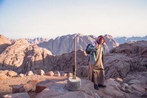 مُسِن سيناوي على أحد الجبال أمام أدواته التقليدية